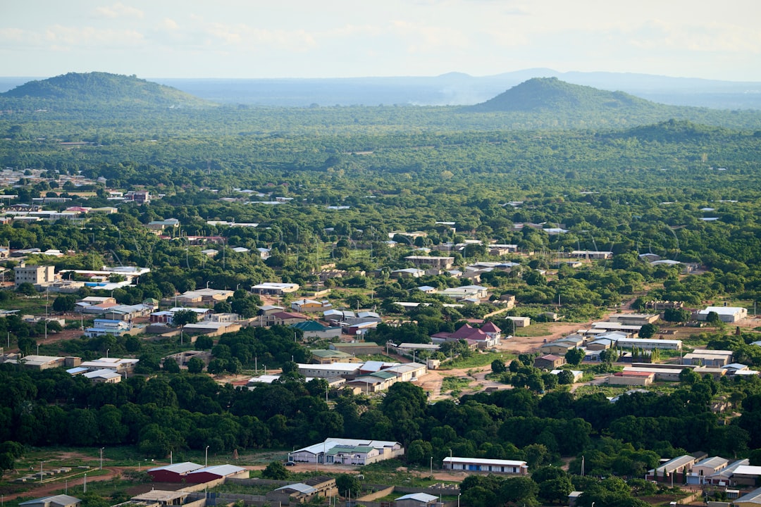 Photograph showing Town surrounded by green trees with distant hills. — illustrating community development programmes in Africa
